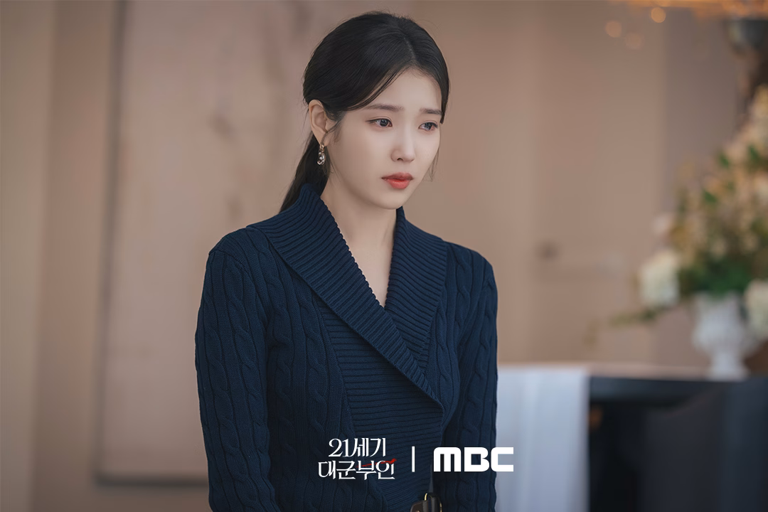 IU kneeling before her father in a dramatic scene