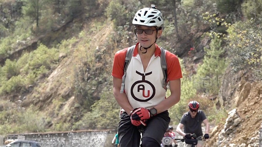 Cyclists riding through Bhutanese landscape