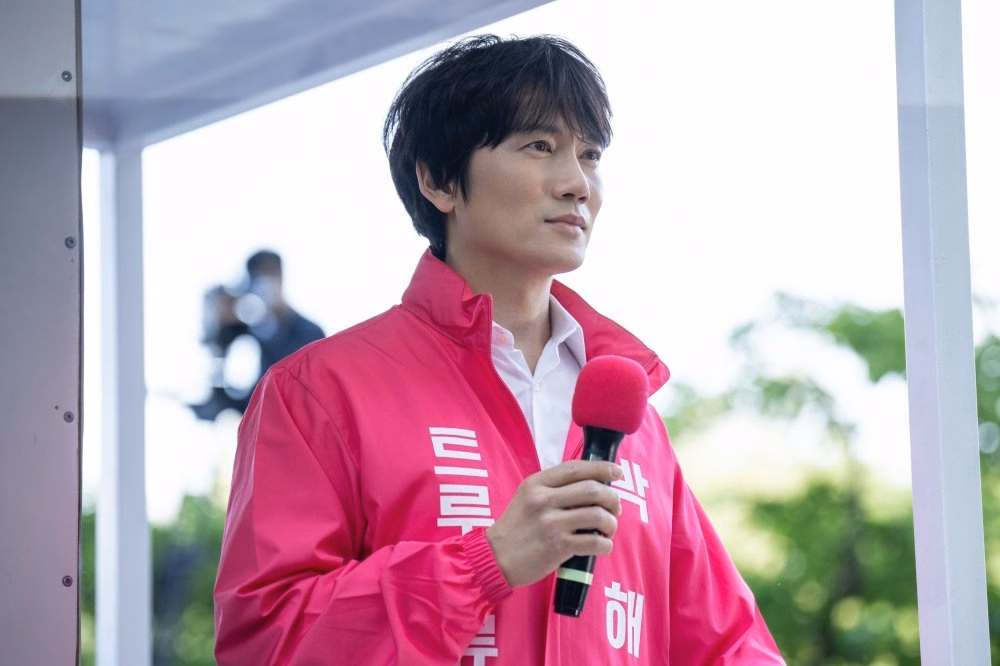 Ha Yun Kyung protects Ji Sung's character with an umbrella during a tense scene