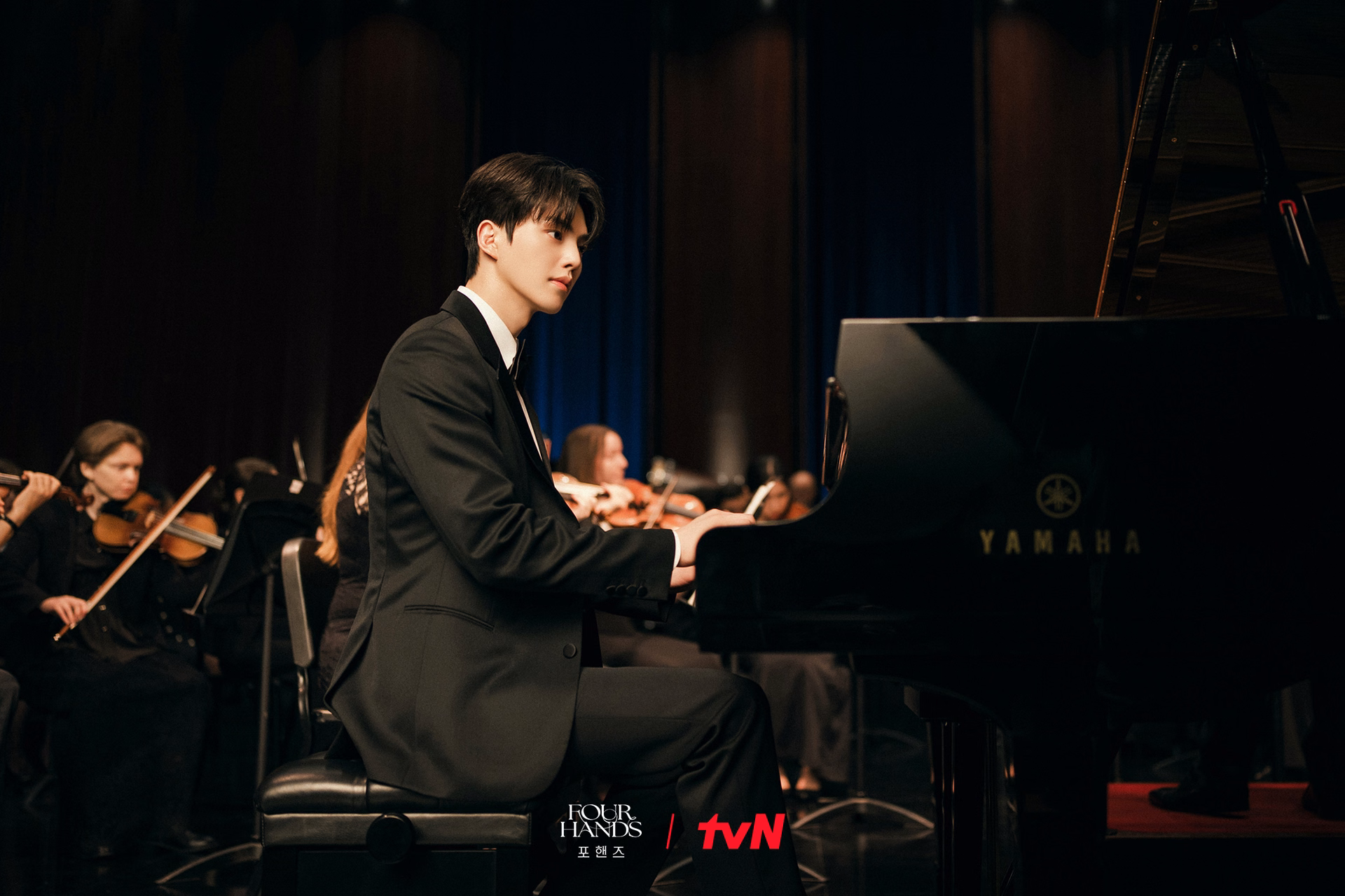 Both pianists performing together with contrasting expressions and postures