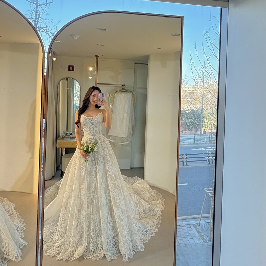 Minhee's elegant pose in her wedding dress during a photoshoot