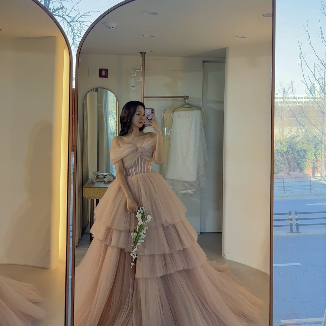 Minhee's serene expression as she admires her wedding gown