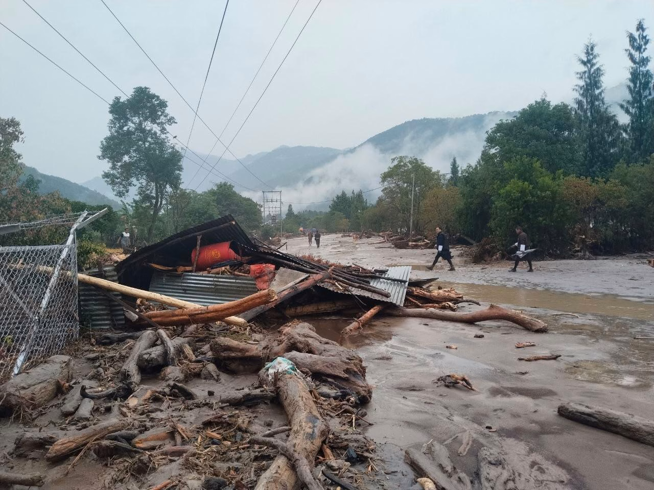 Debris-laden landscape showing the path of destruction along affected areas